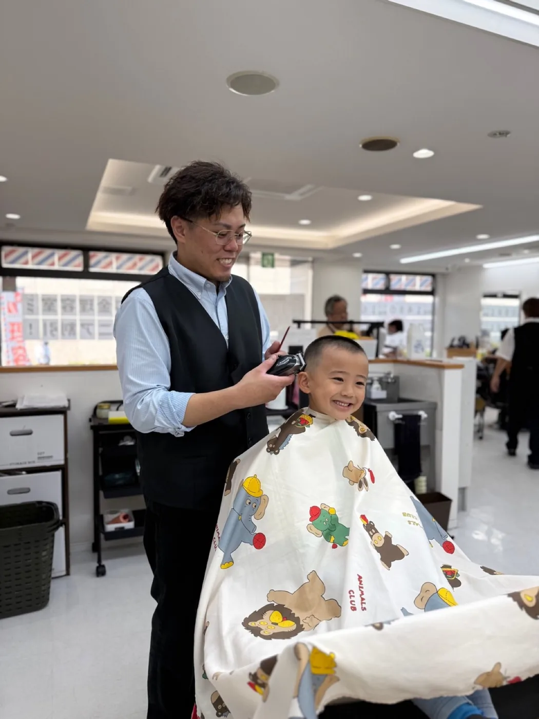 バーバーウッディで笑顔でキッズカットを受けるお子様